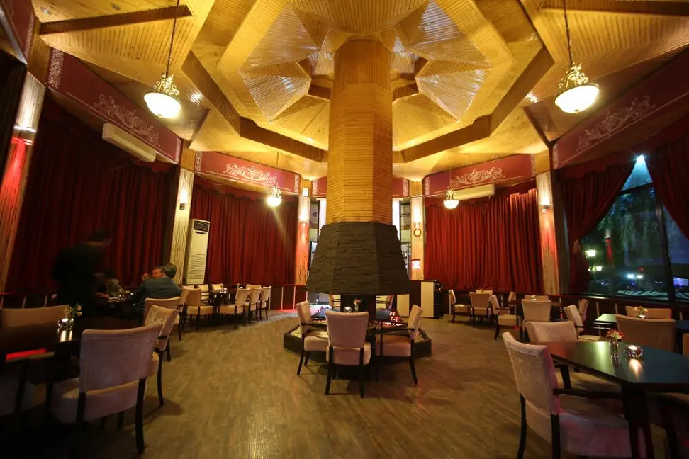 Spacious deluxe room at Eram Grand Hotel with modern amenities for patient recovery